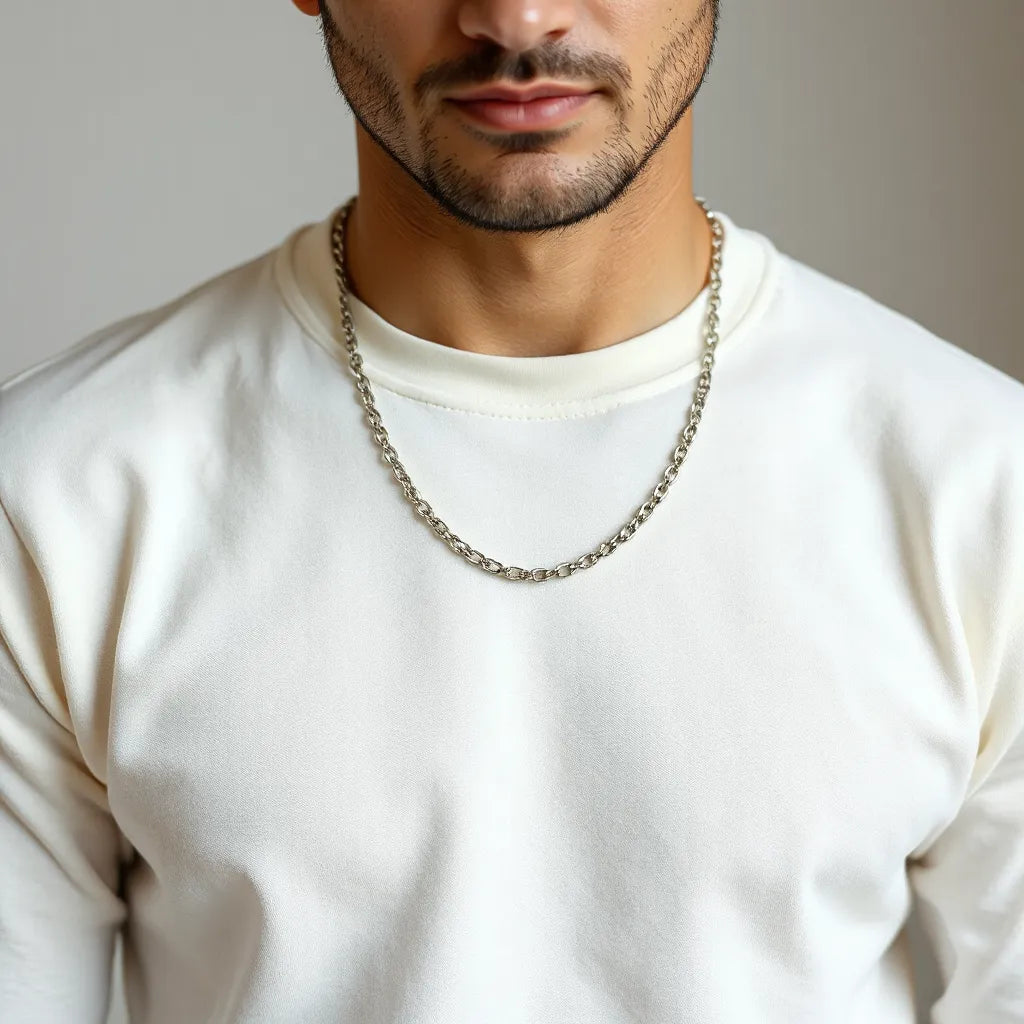 Man wearing a mens silver chain necklace with clear focus on the links against a neutral background