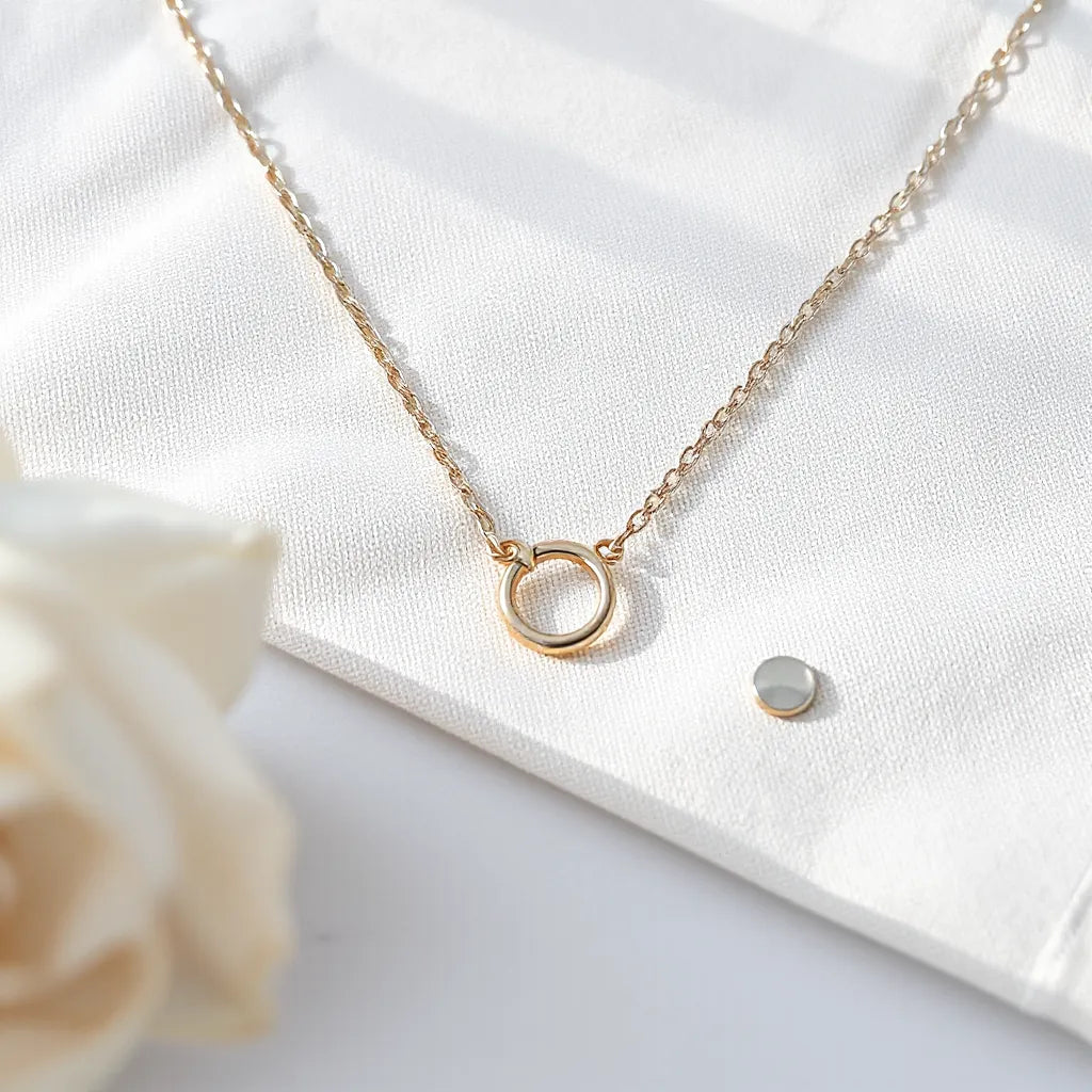 Figaro chain necklace with visible interlocking links on a neutral fabric background