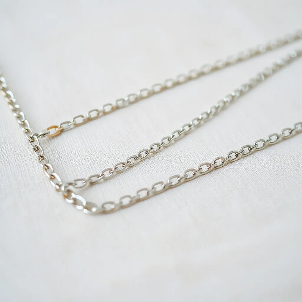 Multiple 925 sterling silver chains laid on neutral fabric, highlighting different link styles and shine