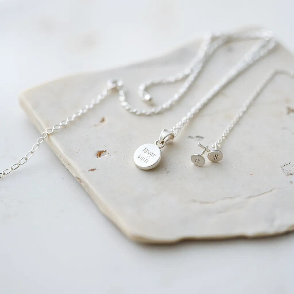 Assorted polished silver jewelry with visible hallmark details under soft natural light