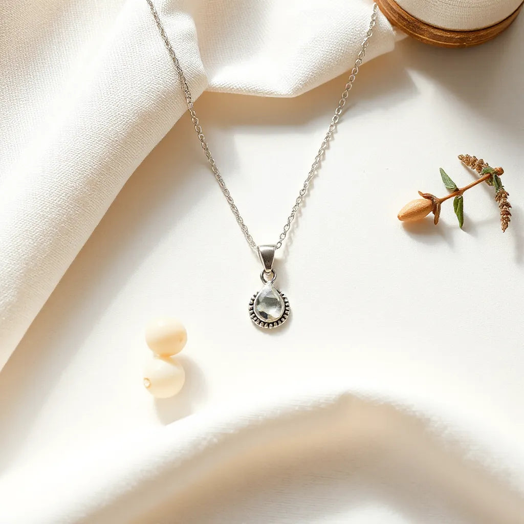 Unisex sterling silver necklace with pendant resting on a light neutral fabric backdrop