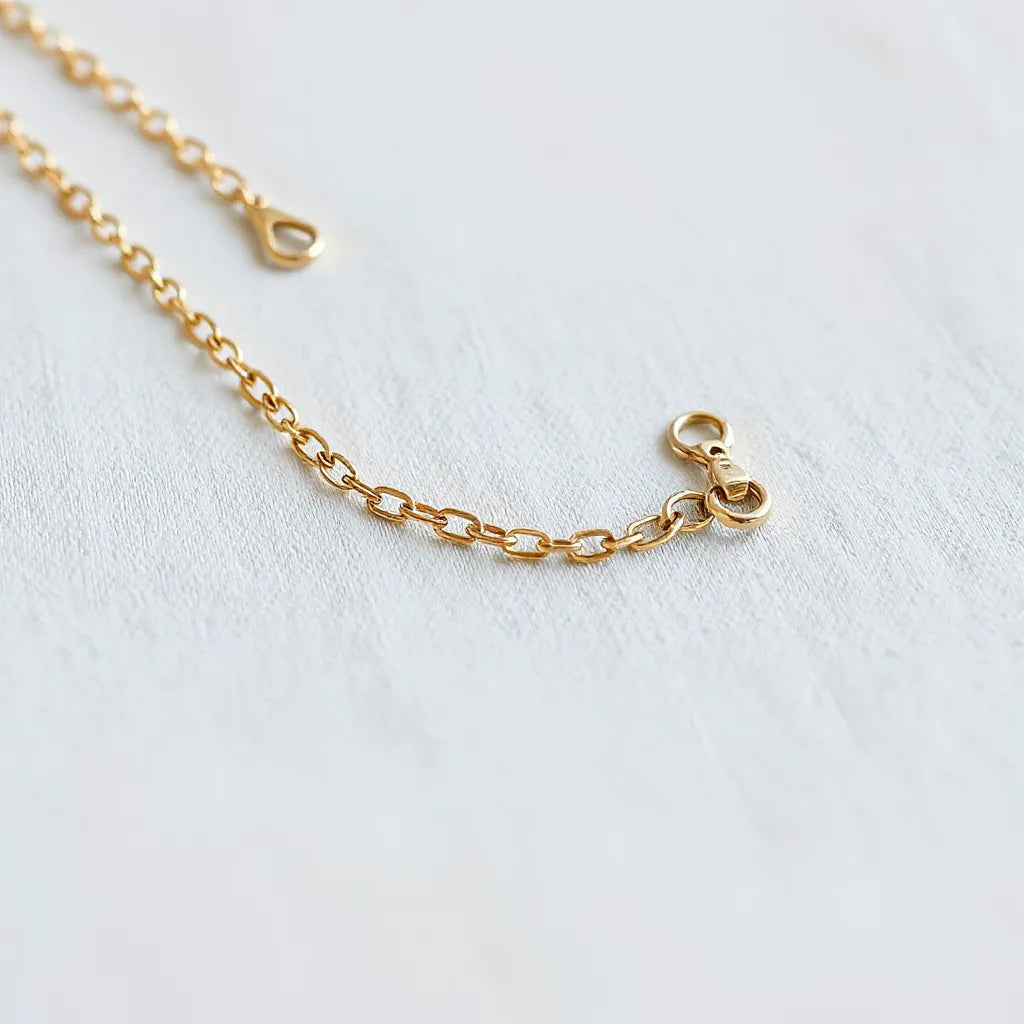 Delicate skin-friendly necklace chain with smooth links resting on soft neutral fabric