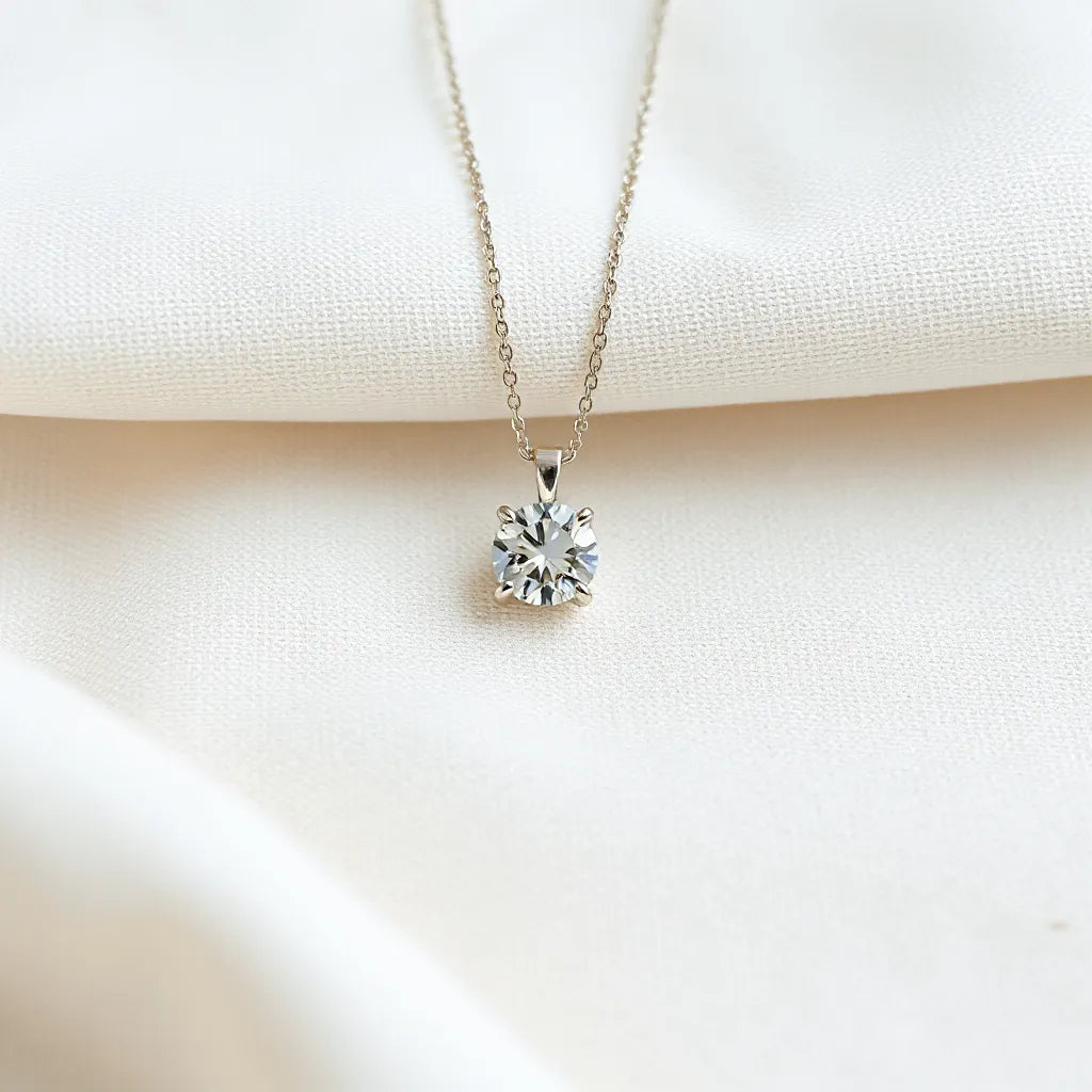 Moissanite pendant with a clear faceted gemstone on a delicate chain against a light neutral background