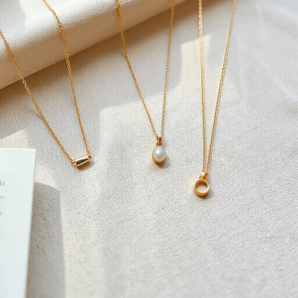 Layered pendant necklaces on beige fabric showing different chain lengths