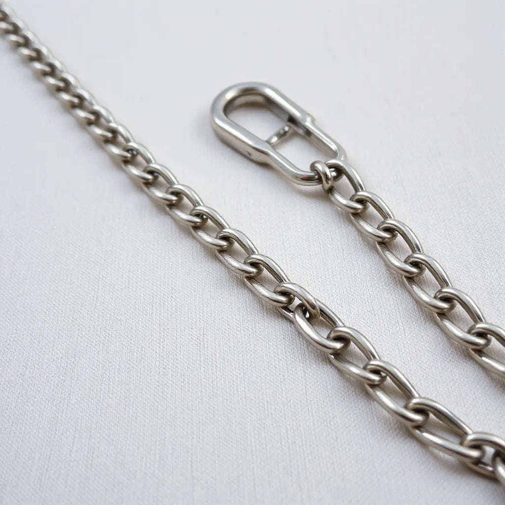 Polished Miami Cuban link chains with reflective metal links on a neutral fabric background