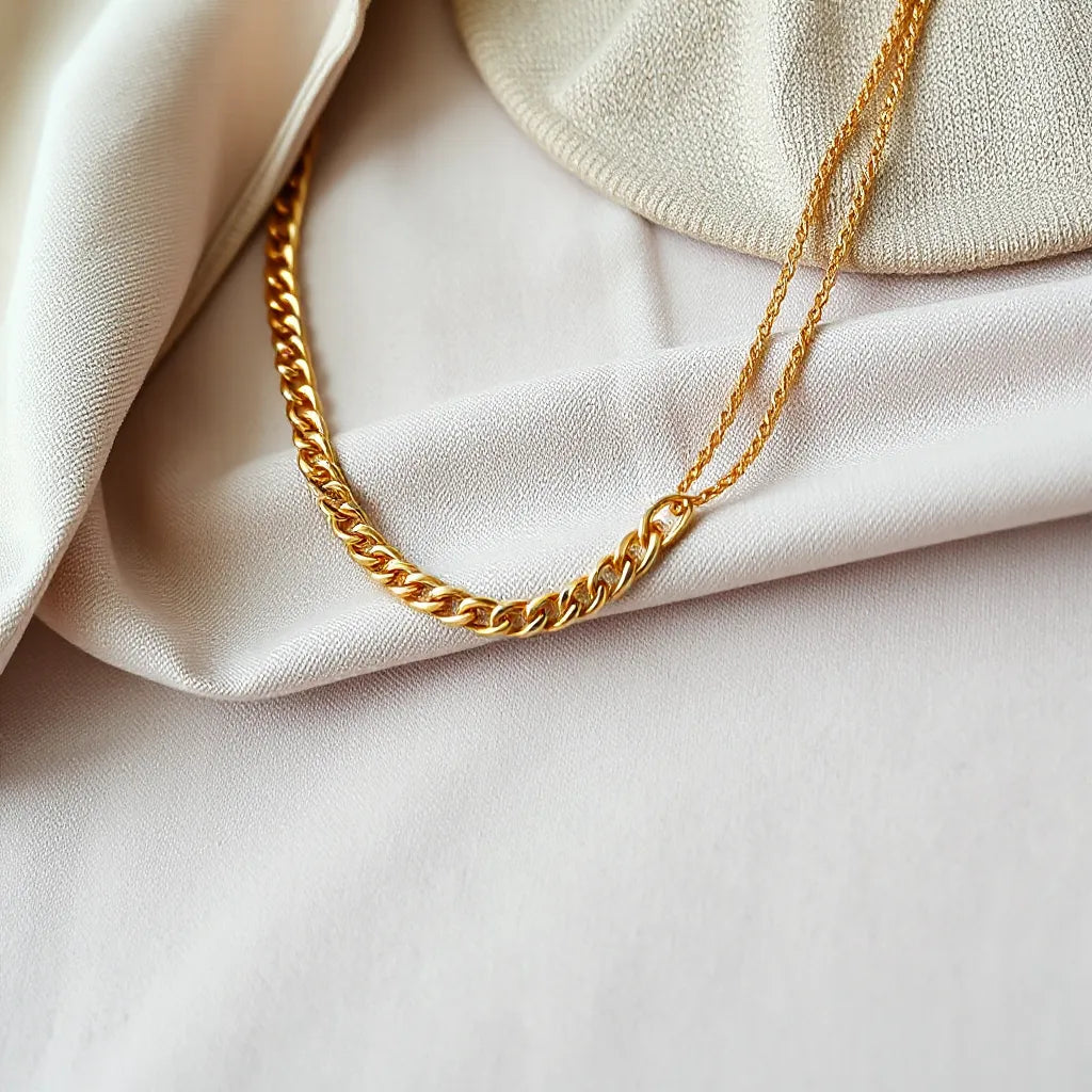 Gold Cuban chain necklace styled with a neutral shirt collar in warm light