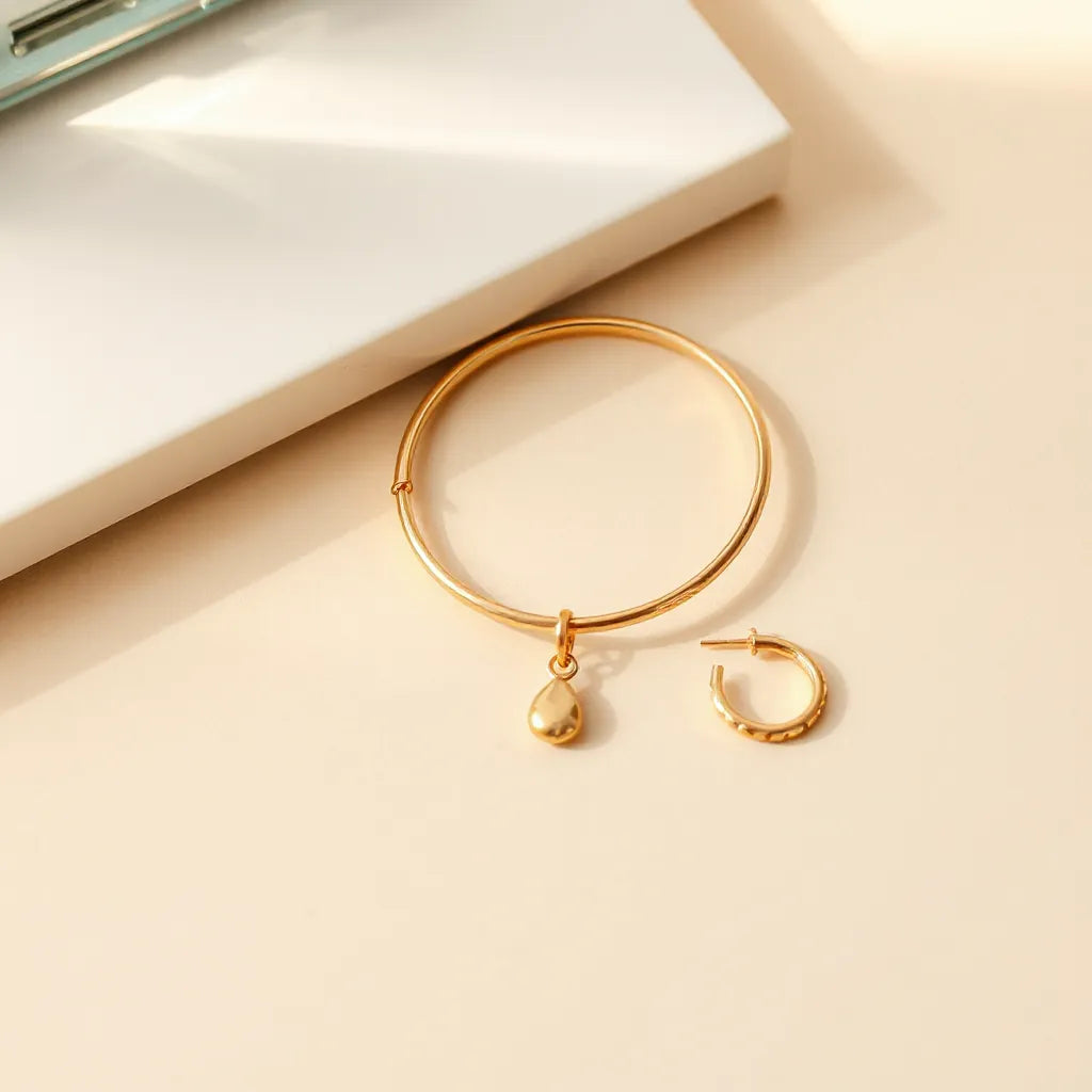 Gold-finished jewelry pieces arranged on a warm neutral background with soft daylight highlights