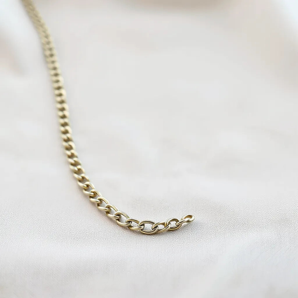 Polished franco chain necklace on light fabric with links sharply highlighted