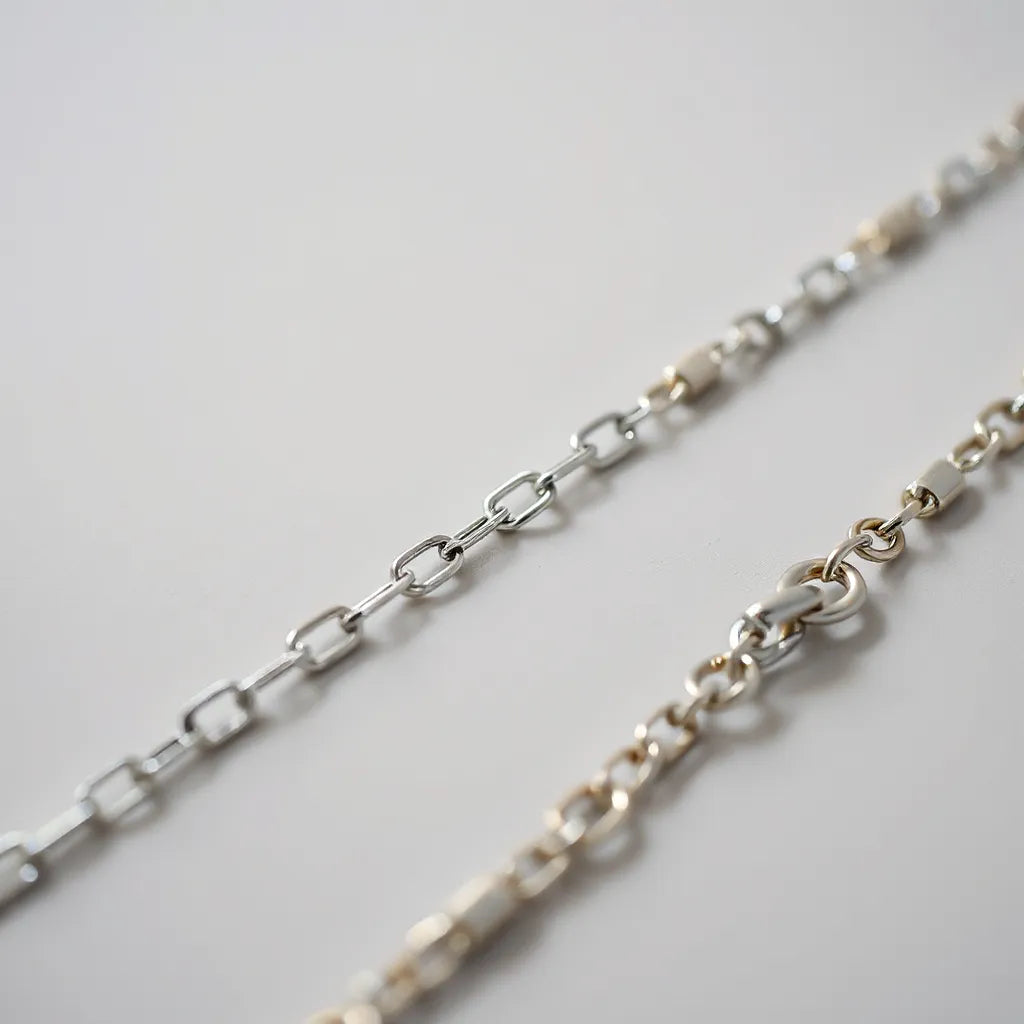 Solid sterling silver chains displayed in neat rows with varied link styles and polished shine