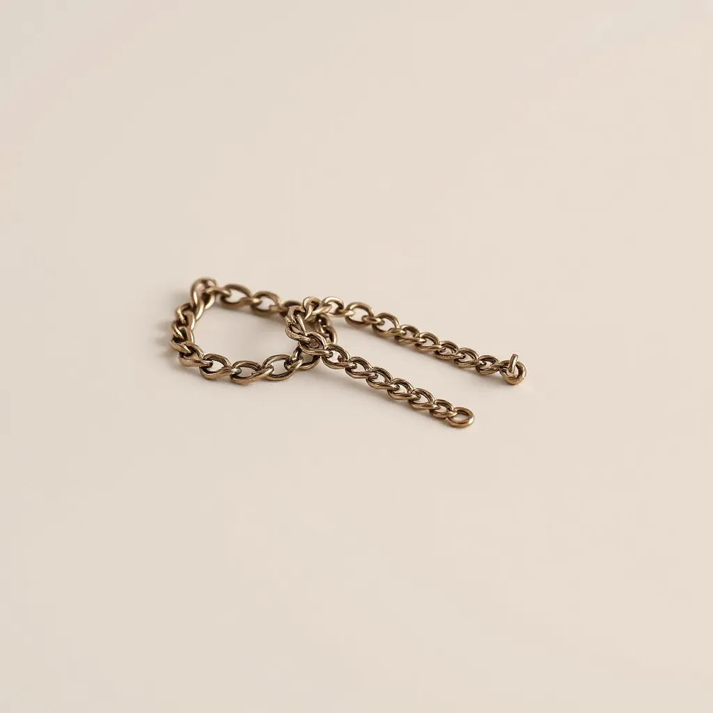Cuban link chains with a bright metal finish arranged on a neutral background