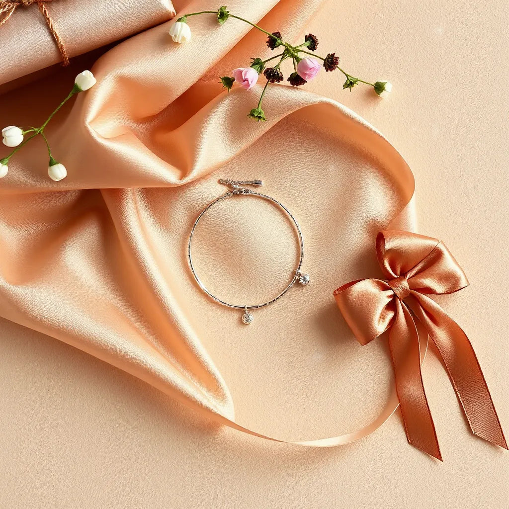 Delicate bracelet and pendant necklace arranged on satin with a minimal ribbon bow