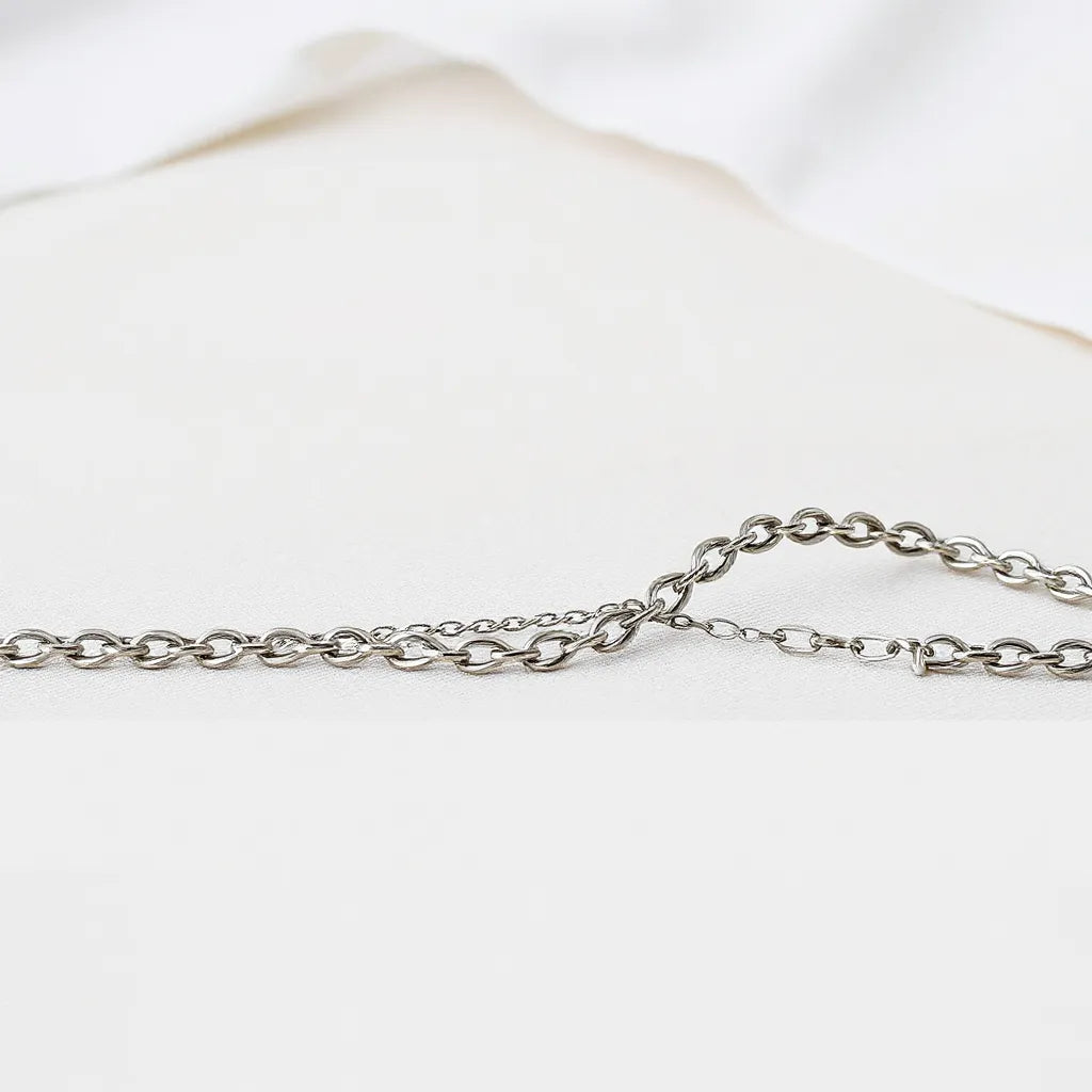 Silver rope chain necklace with visible twisted links on a light neutral background