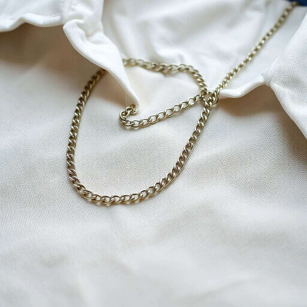 Mens silver chain necklace displayed with a simple shirt collar in soft focus