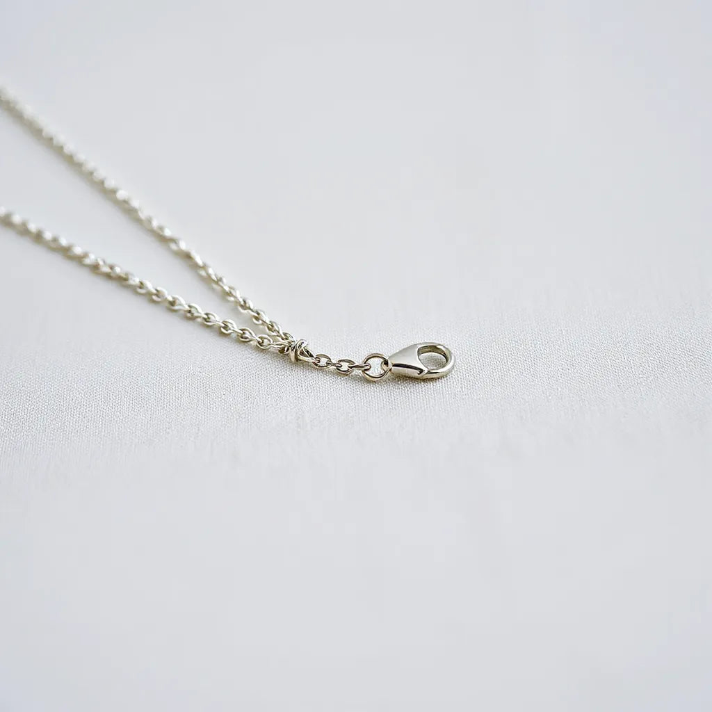 925 silver rope chain necklace with detailed textured links on a light neutral fabric background